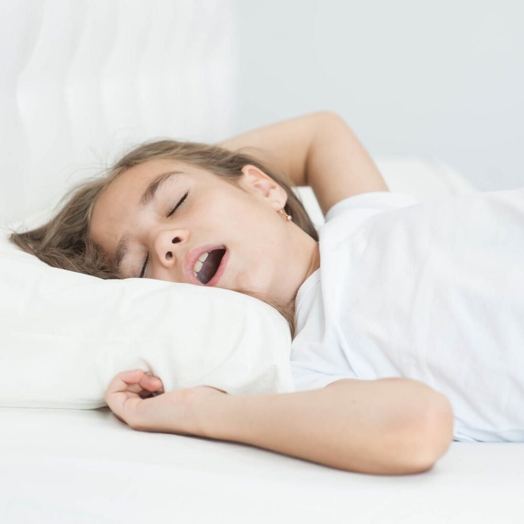 Child sleeping with an open mouth, demonstrating a common sign of mouth breathing during sleep. Image highlighting the relationship between mouth breathing, airway health, sleep quality, facial development, and oral health in children.